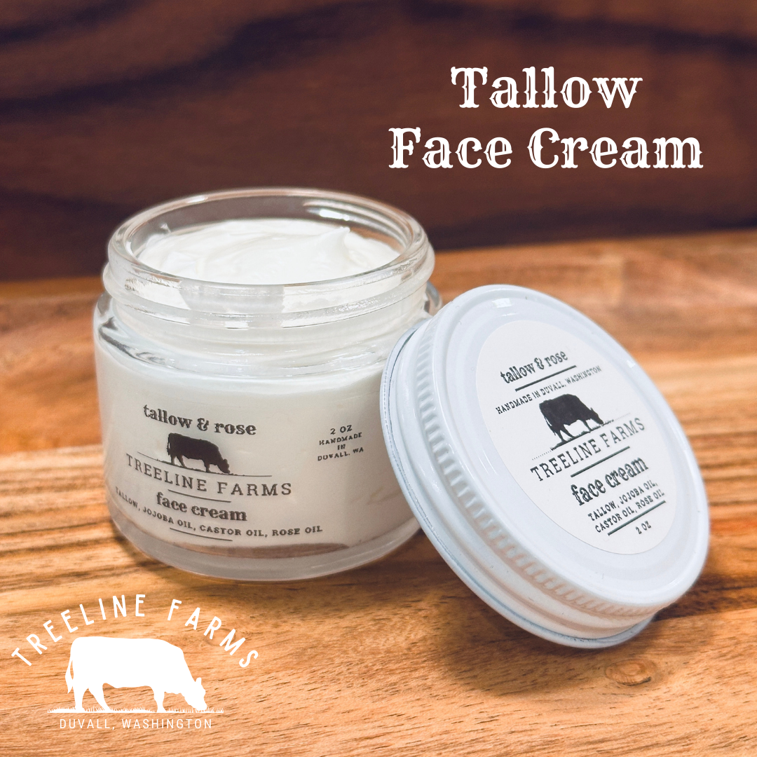 Creamy and white whipped Tallow Face Cream in a clear, glass, 2-ounce jar with metal lid. Ingredients are tallow, jojoba oil, castor oil, and rose oil.