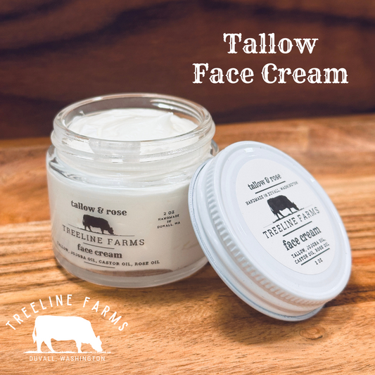 Creamy and white whipped Tallow Face Cream in a clear, glass, 2-ounce jar with metal lid. Ingredients are tallow, jojoba oil, castor oil, and rose oil. 